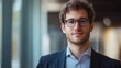 © jambulart - Young man, glasses, suit, serious expression, indoor.