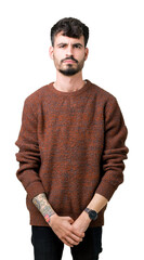 Wall Mural - Young handsome man wearing winter sweater over isolated background skeptic and nervous, frowning upset because of problem. Negative person.