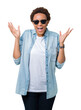© Krakenimages.com - Beautiful young african american woman wearing sunglasses over isolated background celebrating mad and crazy for success with arms raised and closed eyes screaming excited. Winner concept