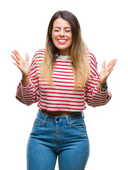 Wall Mural - Young beautiful woman casual stripes winter sweater over isolated background celebrating mad and crazy for success with arms raised and closed eyes screaming excited. Winner concept