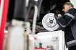 © AS Photo Family - Mechanic inspecting car brake disc in auto repair shop