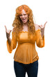 © Krakenimages.com - Young redhead woman shouting with crazy expression doing rock symbol with hands up. Music star. Heavy concept.
