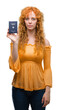 © Krakenimages.com - Young redhead woman holding passport of Germany with a confident expression on smart face thinking serious