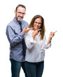 © Krakenimages.com - Middle age hispanic couple in love wearing glasses over isolated background smiling and looking at the camera pointing with two hands and fingers to the side.