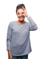 Wall Mural - Young braided hair african american girl wearing sweater over isolated background doing ok gesture with hand smiling, eye looking through fingers with happy face.