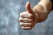 © Alla - A person extending their thumb to give a positive gesture, ideal for expressing approval or agreement