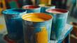 © Infinity Lens - Closeup of metal tin paint cans or buckets with different colors, liquid creativity and expression in design and painting work. home or house repair and renovation, colorful dye renewal.