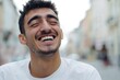 © Alena - A smiling man closes his eyes on a city street