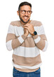 © Krakenimages.com - Handsome man with beard wearing casual clothes and glasses laughing nervous and excited with hands on chin looking to the side