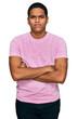 © Krakenimages.com - Young handsome hispanic man wearing casual pink t shirt skeptic and nervous, disapproving expression on face with crossed arms. negative person.