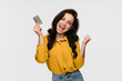 © InsideCreativeHouse - Overjoyed crazy girl woman female student winner wear stylish clothes holding credit card scream yes get salary celebrating success winning gesture isolated on white color background. Banking concept