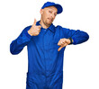 © Krakenimages.com - Bald man with beard wearing builder jumpsuit uniform doing thumbs up and down, disagreement and agreement expression. crazy conflict