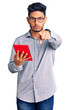 © Krakenimages.com - Handsome latin american young man holding touchpad pointing with finger to the camera and to you, confident gesture looking serious