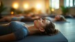 © Olena - A close-up of a yoga instructor assisting a student with a restorative pose in a peaceful indoor space, with soft lighting and calming decor