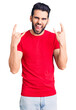 © Krakenimages.com - Young handsome man with beard wearing casual t-shirt shouting with crazy expression doing rock symbol with hands up. music star. heavy concept.