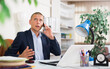 © JackF - Portrait of focused manager sitting at office table, having phone conversation
