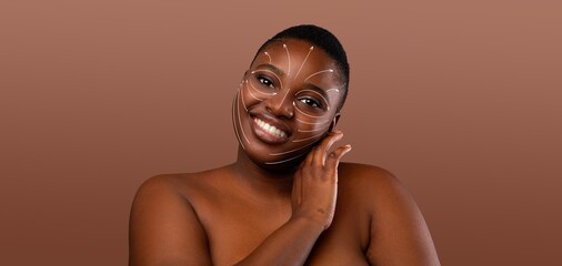 African American woman engages in her skin care routine, smiling as she pampers herself. Her skin is adorned with a unique design, showcasing her beauty in a serene, isolated environment.