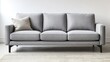 © Poter - Stylish gray sofa with three cushions placed against a minimalist wall in a modern living room. Generative AI