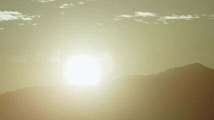 Wall Mural - Sun Setting Behind Mountains In Silhouette Time Lapse