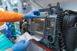 © Raul Navarro/Stocksy - Paramedic using defibrillator device in ambulance