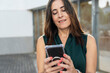 © Manu Prats/Stocksy - Woman entrepreneur working on smartphone outdoors