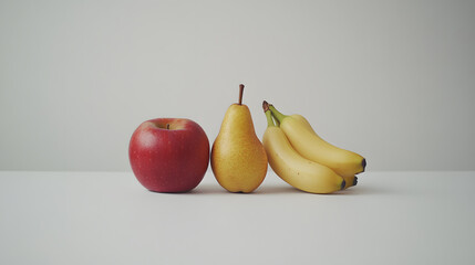 Wall Mural - A red apple, a yellow pear, and two yellow bananas arranged in a row on a white surface against a light gray background. Simple, clean, and minimalist food photography.