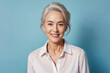 © KayKai - A woman with a white shirt and gray hair is smiling