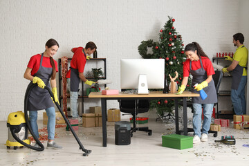 Canvas Print - Team of janitors cleaning in office after New Year party