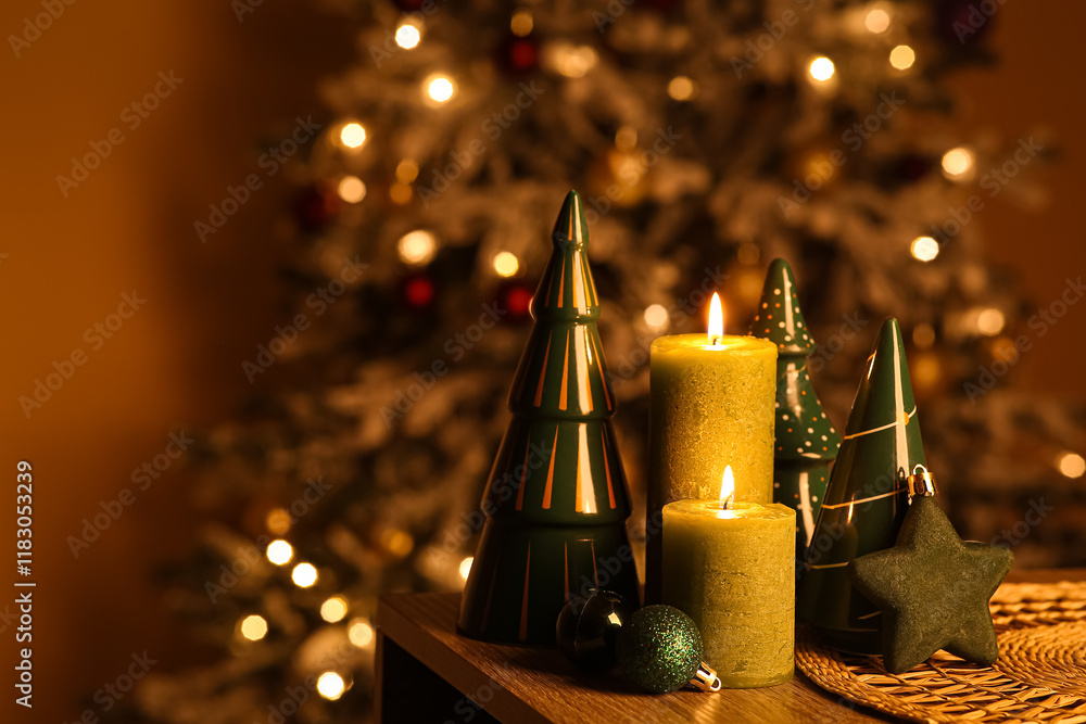 Burning candles and beautiful decorations against Christmas tree in room