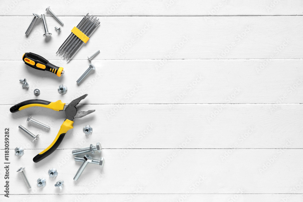 Tap bolts, chrome nuts and tools on white wooden background