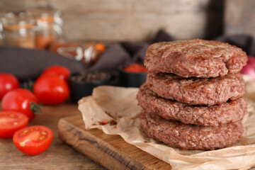 Wall Mural - Board with stack of tasty meat cutlets and tomatoes on wooden background