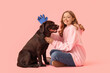 © Pixel-Shot - Young woman with pet glove and her cute dog on pink background