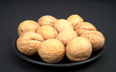 One full plate of dry walnut in black background