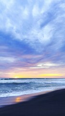 Wall Mural - Stunning Sunset over Black Sand Beach Ocean Waves Crashing Softly on Shore