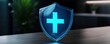© Panisara - A glowing shield icon with a cross symbol, representing protection and security.