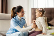© Dusan Petkovic - Smiling pediatrician examining with stethoscope little patient's lungs during home visit.