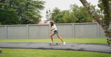 A young woman is skillfully riding a skateboard down a scenic park