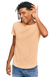 © Krakenimages.com - Young african american man wearing casual clothes smiling with hand over ear listening an hearing to rumor or gossip. deafness concept.