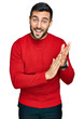 © Krakenimages.com - Young hispanic man wearing casual clothes clapping and applauding happy and joyful, smiling proud hands together