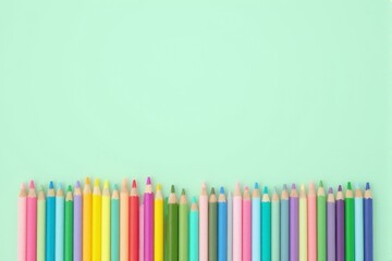 Wall Mural - A neat row of pastel colored pencils on a matching pastel mint background