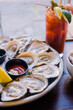 © Cavan Images - Fresh raw oysters on ice with lemon and a loaded Bloody Mary.
