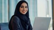 © Vadim - Focused young middle eastern businesswoman working on laptop with a smile in a professional setting