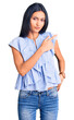 © Krakenimages.com - Young beautiful latin girl wearing casual clothes pointing with hand finger to the side showing advertisement, serious and calm face