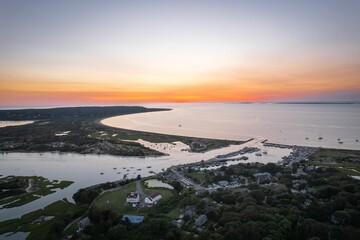 Canvas Print - Aerial sunset view of coastal town and harbor.