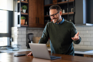 Canvas Print - Successful happy professional business man working on her laptop in a bright home office