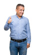 © Krakenimages.com - Middle age arab business man over isolated background doing happy thumbs up gesture with hand. Approving expression looking at the camera showing success.