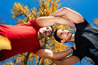 © Studio Marmellata - Two male runners, one in a red shirt and one in black, pose together under vibrant yellow autumn leaves, creating a symmetrical and dynamic composition against a backdrop of a clear blue sky.