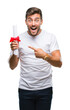 © Krakenimages.com - Young handsome man holding degree over isolated background very happy pointing with hand and finger