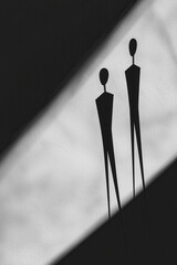 Abstract Black and White Silhouette Figures on Textured Surface with Geometric Shadows