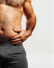 man grabbing belly fat on white background: weight loss concept